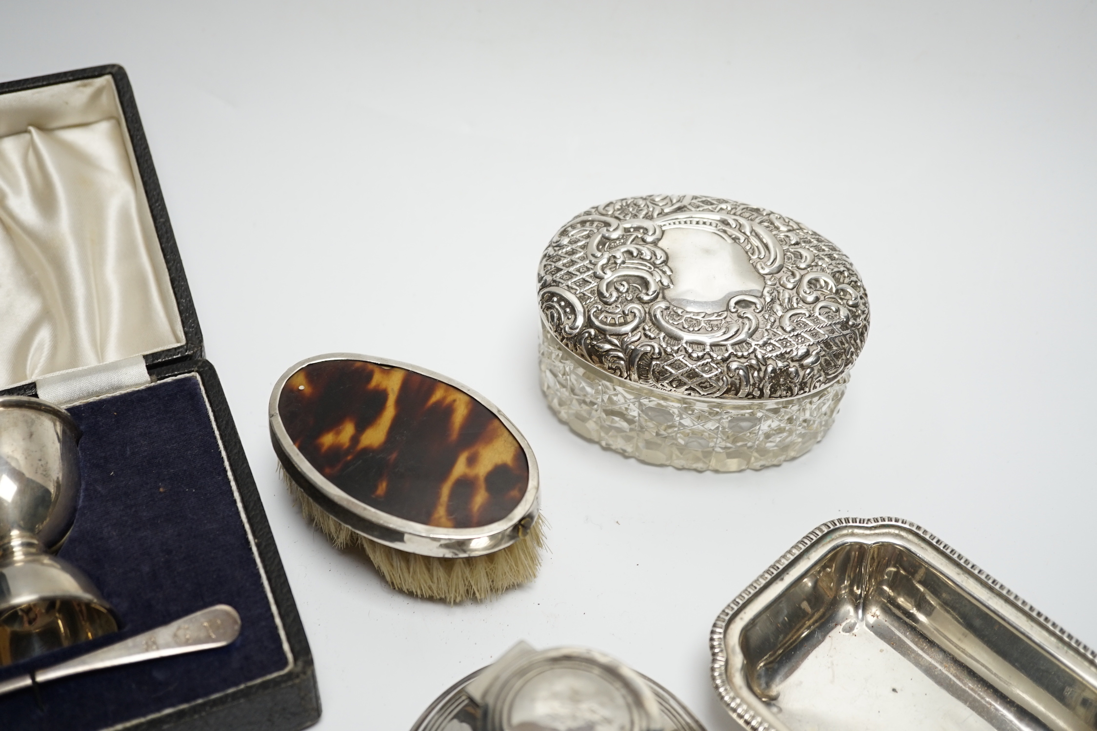 A cased silver christening egg cup and spoons and other items including nail buffers, inkwell, brushes etc.